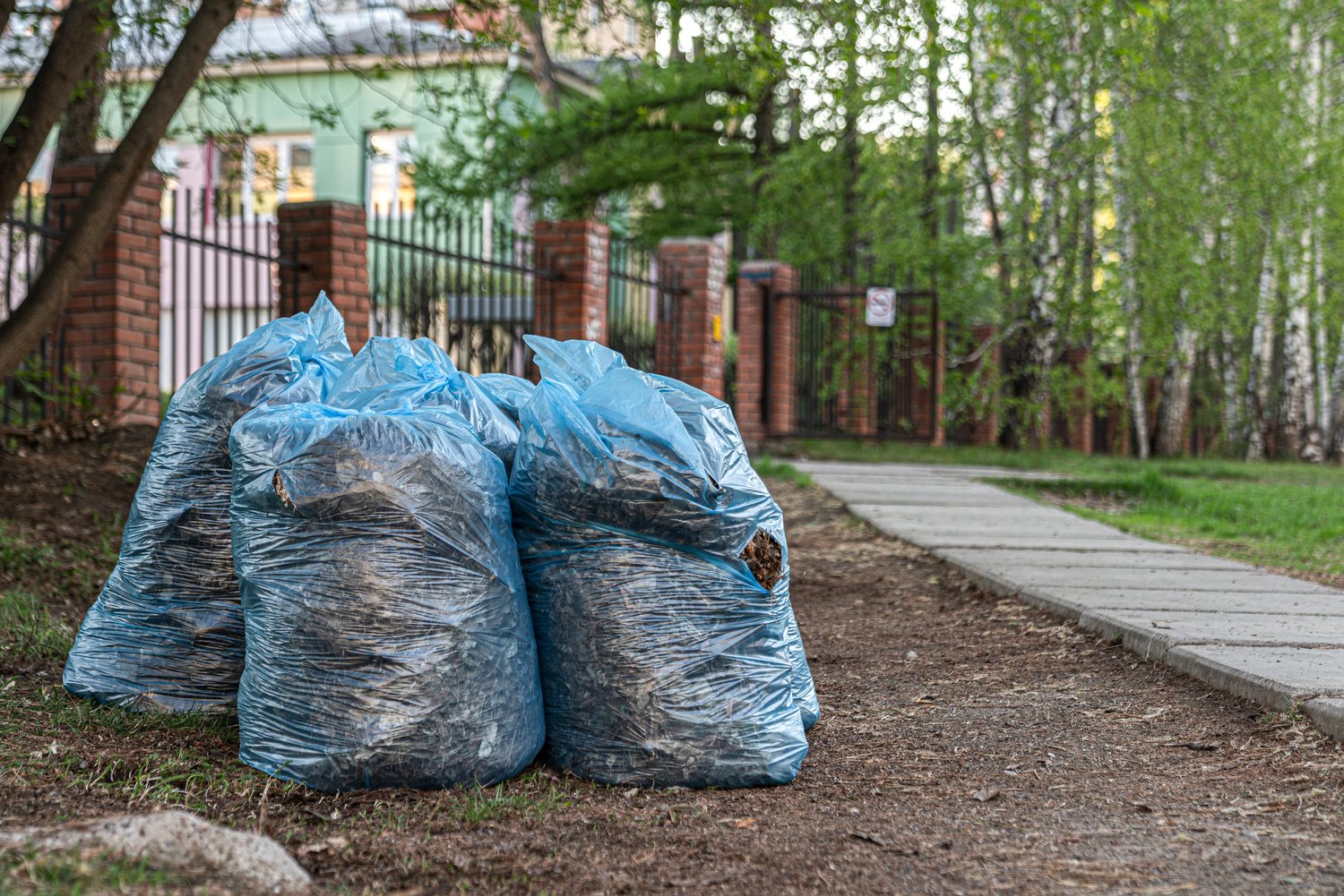 bags of grass and garbage are piled up. cleaning residential yards